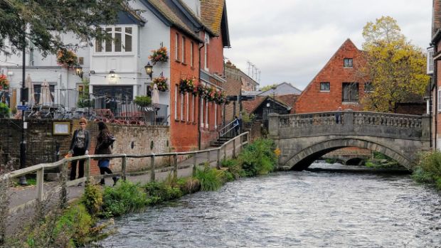 The fast-flowing River Itchen at the Weirs, with the bridge and the City Mill behind.